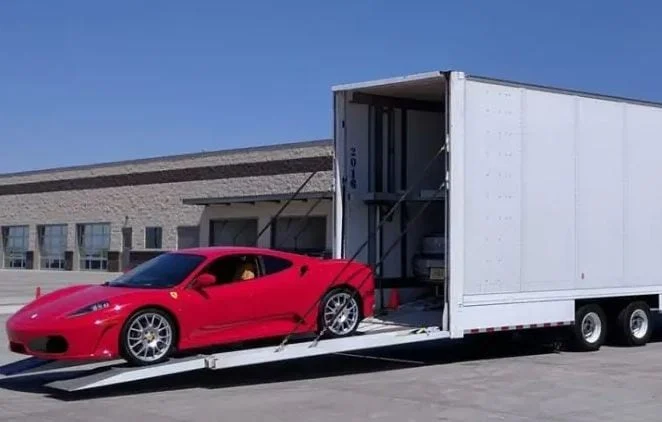 Enclosed car transport trailer with a red sports car